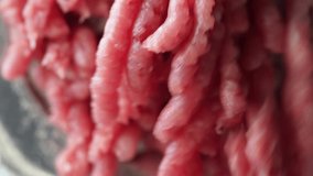 Closeup view 4k video of home electric mince machine making minced meat of fresh pork.