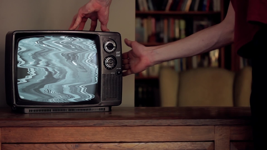 Man hitting an Old TV with no Signal and Noise on a Screen that goes Green. You can replace green screen with the footage or picture you want. You can do it with “Keying” effect in After Effects. | Shutterstock HD Video #1048833841