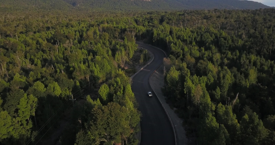 Aerial drone footage following a white pickup truck along a serpentine road in the south of Chile. Royalty-Free Stock Footage #1048833994