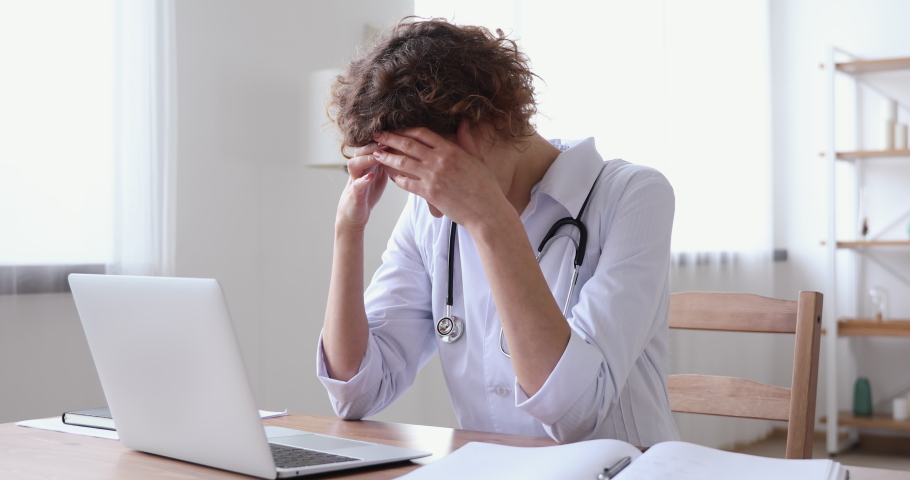 Stressed upset young female doctor feeling worried about professional malpractice. Depressed tired physician regrets medical diagnosis mistake suffers from guilt or headache sitting alone in office. Royalty-Free Stock Footage #1048839313
