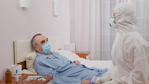 Control of Coronavirus epidemic and pandemic prone acute respiratory diseases. Temperature measurement of a sick elderly man during an epidemic.