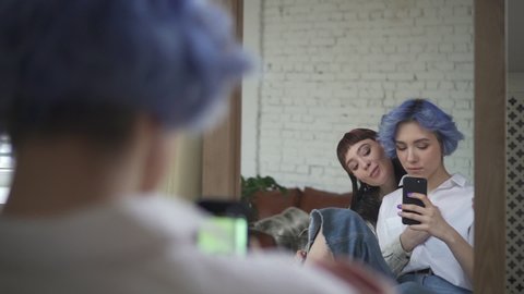 lesbian couple taking selfie in the mirror. kissing girls take picture. concept loving, same sex, Spbd homosexual. photo on phone. interacting communication during leisure time