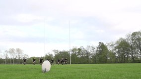 Scoring a conversion with a Rugby Kick. A player is kicking the Unbranded ball during a match through the rugby posts. Super Slow motion. Stock Video Clip Footage