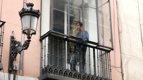 a neighbor from the center of Madrid playing the saxophone on the balcony of his house locked up by the state of alarm in Spain by COVID-19. Filmed on March 23, 2020.
