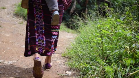 The Feet of a Guatemalan Woman Carrying her baby walking home in traditional woven skirt