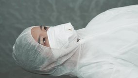 Asian woman in protective mask, Chinese coronavirus, quarantine zone, female laboratory assistant in chemical protection, portrait of a woman, vertical video.