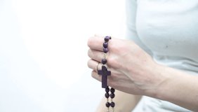 woman praying and holding cross in her hands on white background stock video