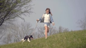 little girl running with her dog in the countryside