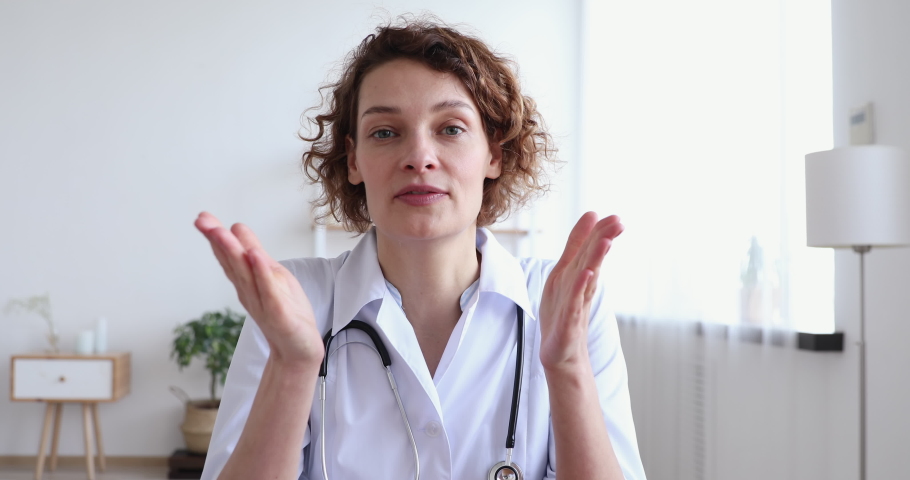 Professional female doctor talking looking at camera making conference video call. Physician speaking to web cam chatting with patient online providing remote e health medical assistance concept Royalty-Free Stock Footage #1048870810