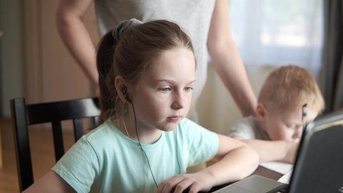Стоковое видео: Girl learning on computer at home, online education, distance learning due quarantine, mother helps with homework.