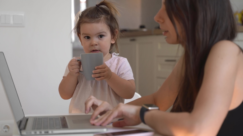 Mother working from home with baby toddler. Crying child and stressed woman. Stay home | Shutterstock HD Video #1048886137