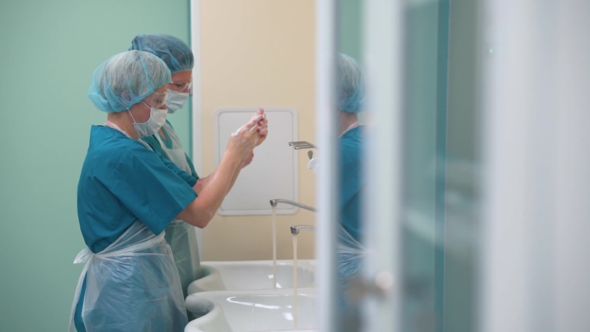 Doctors in masks wash their hands thoroughly before surgery in quarantine Royalty-Free Stock Footage #1048889119