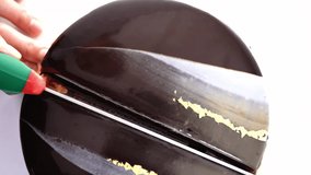 Close up chocolate frosting with gold foil garnish on delicious premium cake. macro, panning shot. - Powered by Shutterstock - Get 15% off with code: PIKWIZARD15