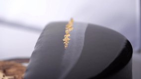 Close up chocolate frosting with gold foil garnish on delicious premium cake. macro, panning shot. - Powered by Shutterstock - Get 15% off with code: PIKWIZARD15