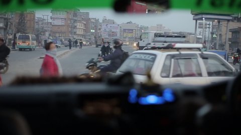 Kathmandu, Nepal - 19 November 2019: A car waiting for people to cross the road in Kathmandu, Nepal. View from drivers seat.