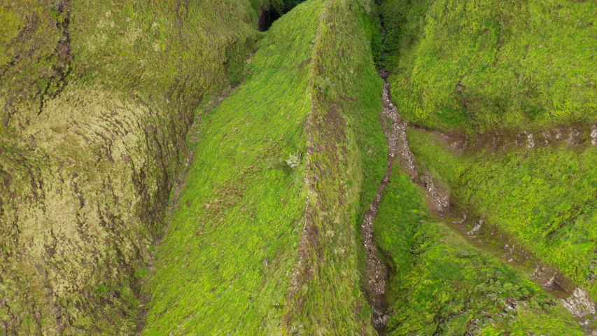 Na Pali Coast State park. Amazing natural relief of Hawaii island. Impressive travel location. Ribbed slopes covered with exotic greenery look fantastic with its green and ruby surface. Aerial. 4K