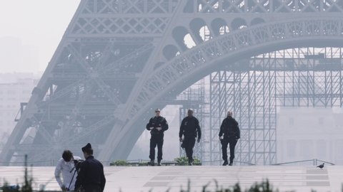 Paris, France - 03 20 2020: Policeman controlling cameraman during coronavirus / Covid-19 crisis in Paris France, near Eiffel tower