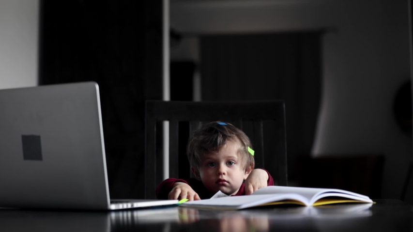 toddler boy is playing with working documents and other parents tools
