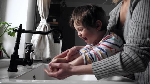 mother washing hands with a toddler boy