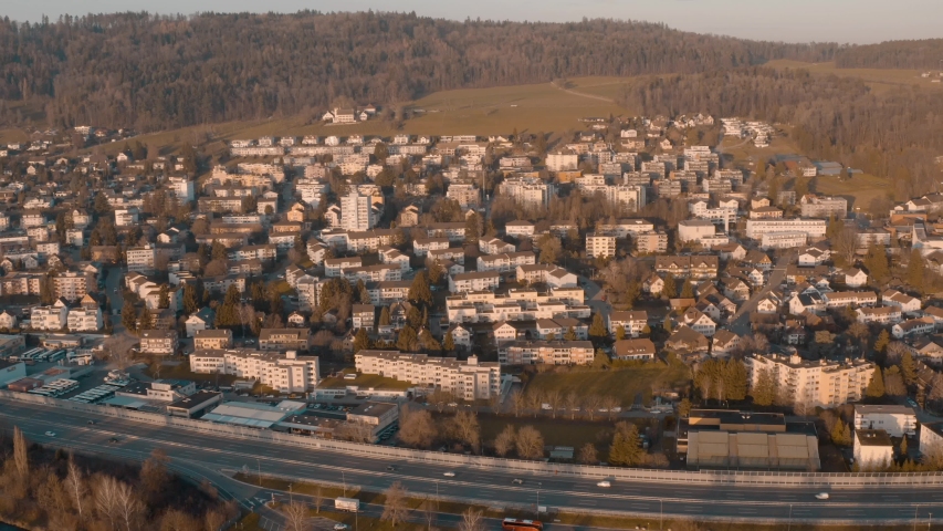 urban settlement with a highway in front and a river. A backwards drone shot