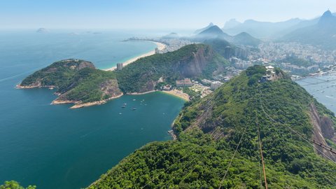Wide panoramic aerial timelapse of the city of Rio de Janeiro in Brazil. View of Copacabana, Ipanema, Botafogo, Flamengo neighborhoods. Ocean and bay, hills and mountains with Christ the Redeemer on M