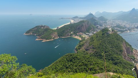 Wide panoramic aerial timelapse of the city of Rio de Janeiro in Brazil. View of Copacabana, Ipanema, Botafogo, Flamengo neighborhoods. Ocean and bay, hills and mountains with Christ the Redeemer on M