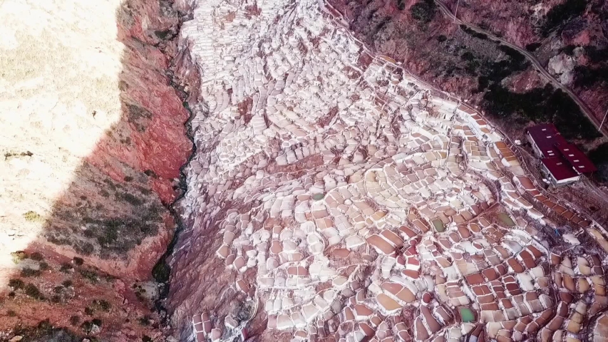 Aerial view of a Salinas in Peru. Drone footage of Salt Mines in Valle Sagrado Peru. Drone view of the white and brown Salt Mines in South America.