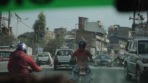 Kathmandu, Nepal - 15 November 2019: Nepalese people crossing busy street, road in Kathmandu, Nepal. View from a car.