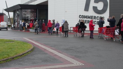 covid 19 covid19 FRANCE: long line of people waiting to enter supermarket to buy food. queue from parking lot to entrance. french old people preparing weeks of containment at home Angers, Lock down