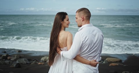 In the middle of amazing seaside landscape romantic young couple have a perfect time together they hugging each other and feeling in love.