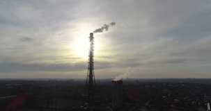 Close up long factory chimney from Drone staying in the middle of city.4k video with view of chimney from the high in city Kharkov, Ukraine.City air industry pollution concept .