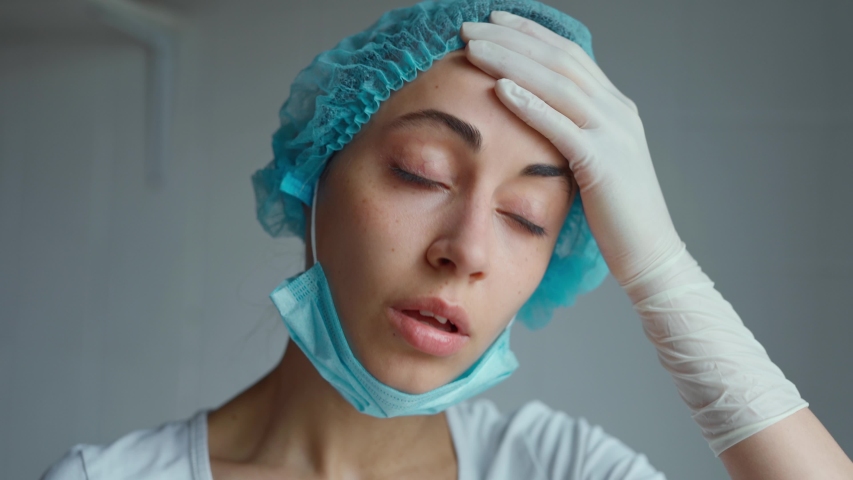 close up woman medic in protection mask looking very tired, exhausted, frustrated after receive patients in hospital. medical staff epidemic concept Royalty-Free Stock Footage #1048978354