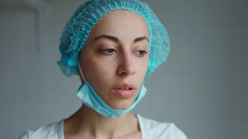 Portrait female doctor or nurse in uniform feeling down, exhausted, frustrated, very tired after receive patients in hospital. Woman looking straight at camera. Hard work, medical, epidemic concept Royalty-Free Stock Footage #1048978360