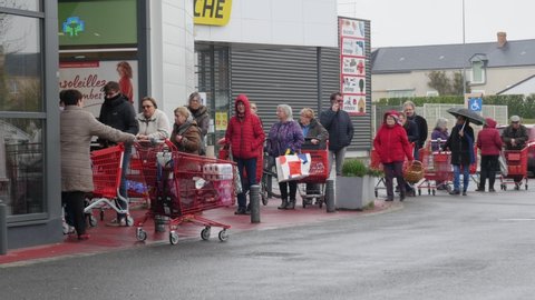 Covid-19 crisis in FRANCE: people waiting in line in front of supermarket to buy food. queue until parking lot. french old people preparing weeks of containment at home. Angers,  covid 19 of covid19