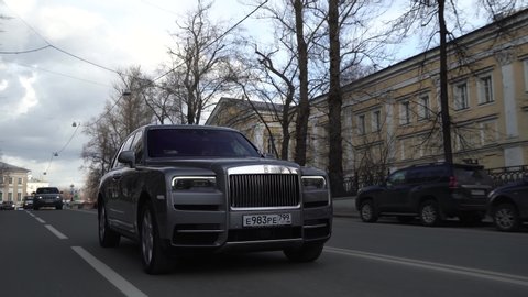 Moscow, Russia - 13 03 2020: Expensive status car moves forward along the street. Gray Rolls Royce Cullinan rides on road in city.