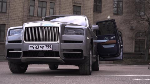 Moscow, Russia - 13 03 2020: Rolls Royce Cullinan stands parked on a street in an expensive quarter. The rear passenger door automatically closes.