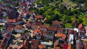 Aerial view of the village Mudau in Germany.  Camera pans left and then rotates right, tilts down.