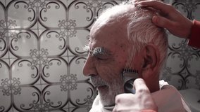 80 years old elderly turkish muslim man getting his hair cut in his vintage bathroom from 1980's - Powered by Shutterstock - Get 15% off with code: PIKWIZARD15