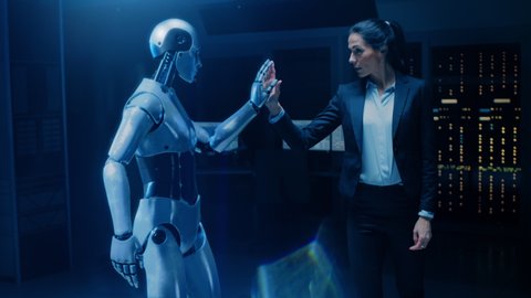 Beautiful, Confident Female Engineer Touching Hands with Humanoid Robot Activating Collaboration, Teamwork Protocol. Computer Artificial Intelligence Concept: People and Robots Working Together