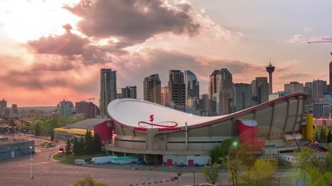 CALGARY, CANADA - MAY 9, 2015: Sunset Timelapse (static crop) of Scotiabank Saddledome with Calgary downtown skyline, and new foot bridge over Elbow River replaces 2013 flood washed out bridge.