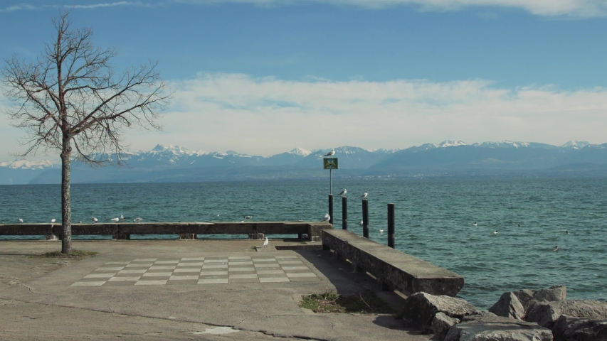 Lakeside park with chess game and the signboard of the city of Rolle