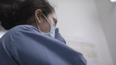 Low angle shot of nurse checking mask during the coronavirus pandemic.