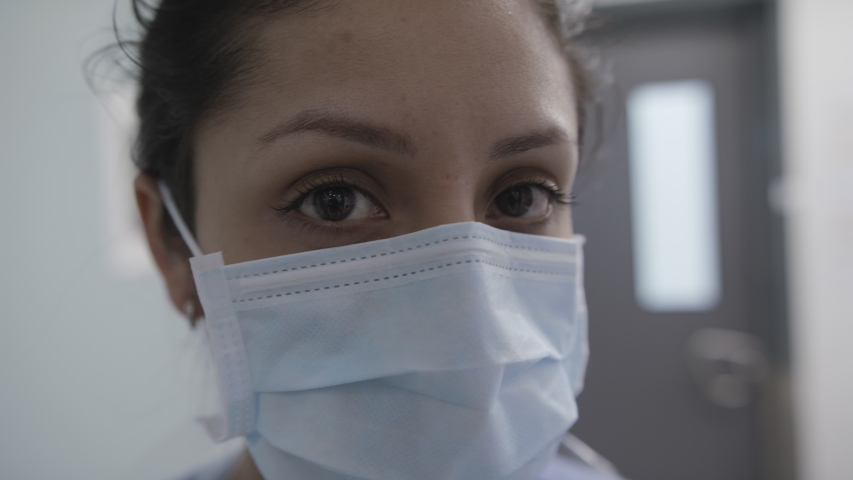 Closeup of nurse with mask turning and looking at camera Royalty-Free Stock Footage #1049010895