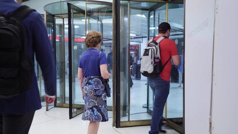 NEW YORK, NY / UNITED STATES - JUL 11 2019: People walking through revolving glass doors