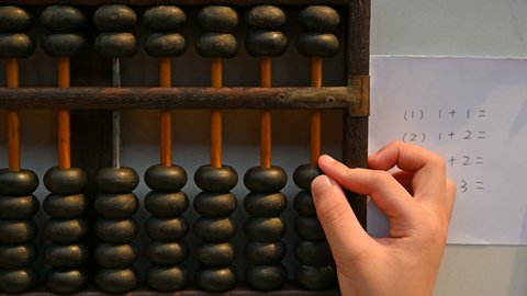 kid using abacus to calculate some simple addition equations