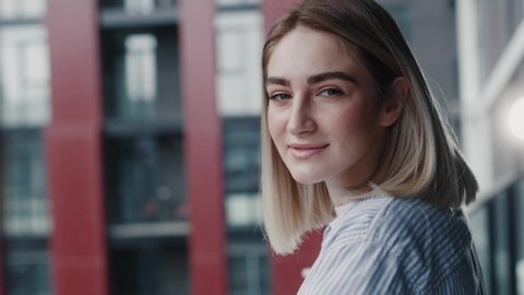Close up portrait of cheerful young blonde hair woman staying on balcony looking to the camera smiling having fun enjoying freezing air slow motion