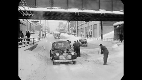 CIRCA 1942 - Cars drive on a snowy city street in Ottawa, Canada, where men use shovels and pickaxes to clear the street of snow and ice.
