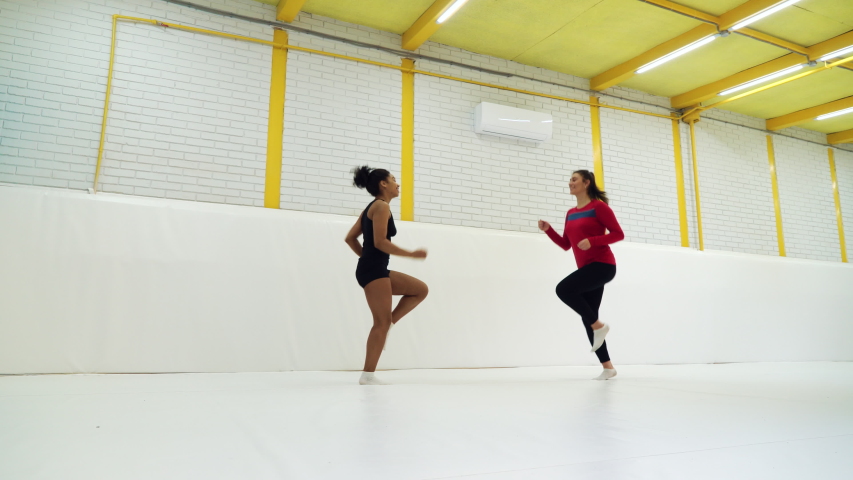 Diverse girls in sportswear running on spot in big gym