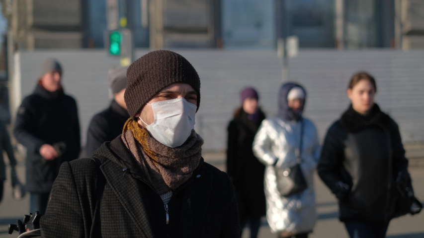 European man in face mask city street under Covid-19 pandemic 2021. Europe infected, coronavirus flu epidemic. Human person masked against 2019-ncov corona virus. US people crowd sick with covid 19. | Shutterstock HD Video #1049039362
