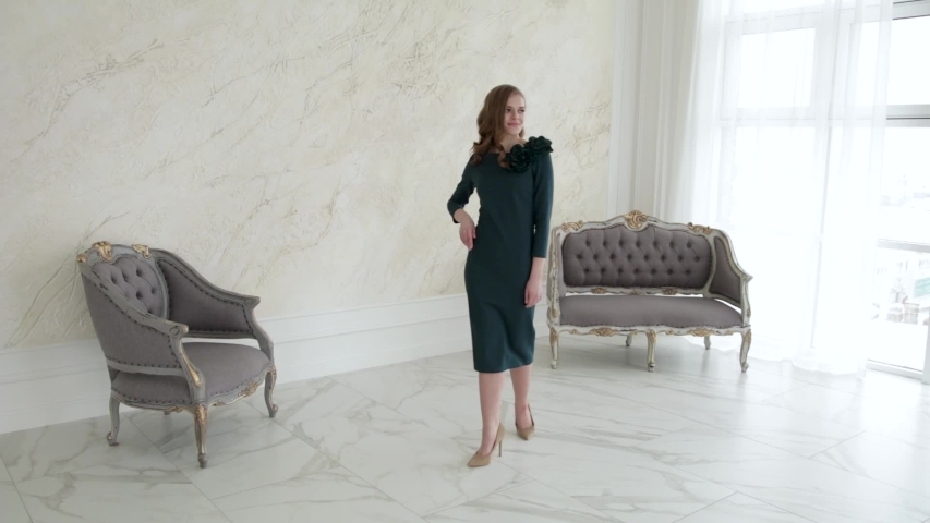 Attractive girl model posing smiling in a dress.Slow motion